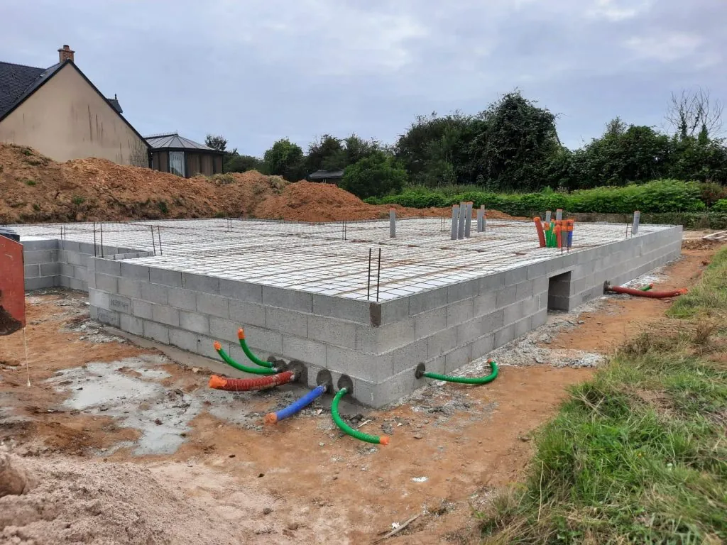 Coulage de fondations solides en béton armé pour la construction d'une nouvelle maison dans le Doubs.